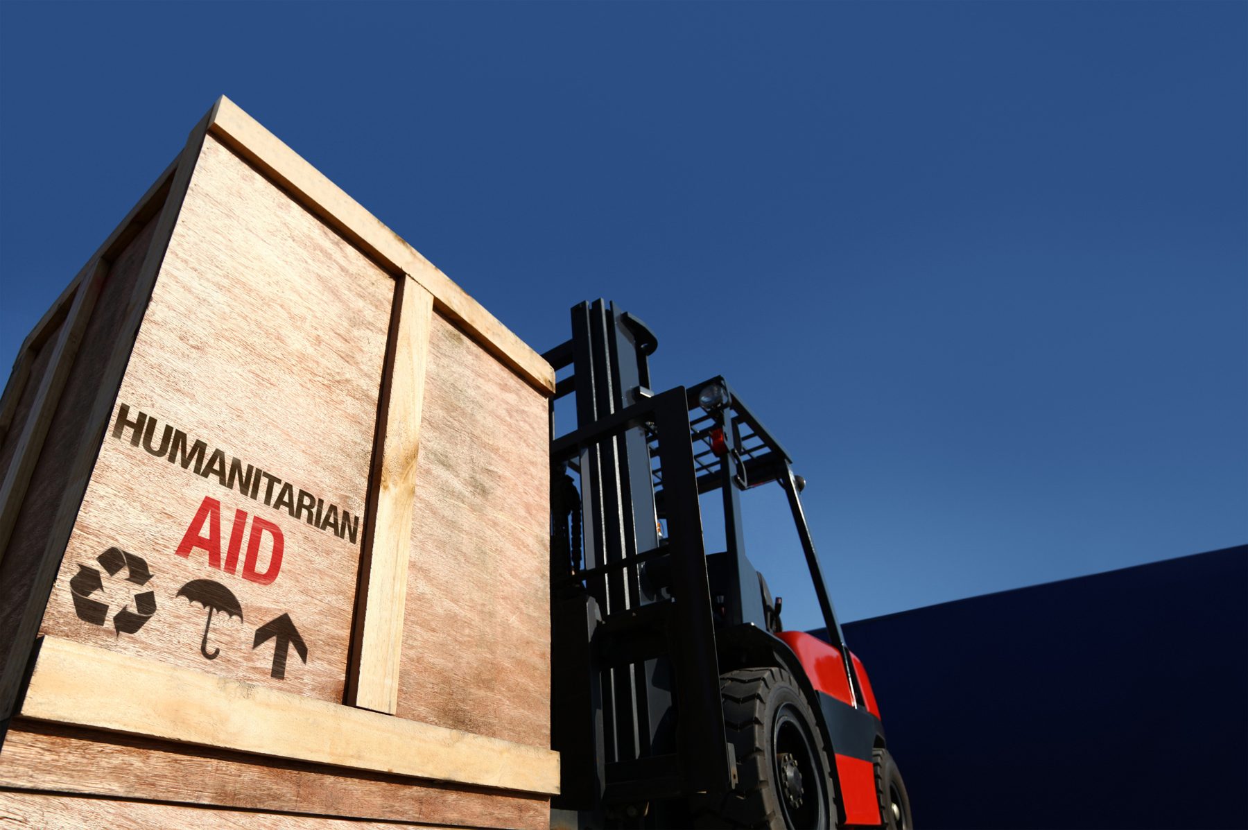 A crate marked humanitarian aid beside a forklift